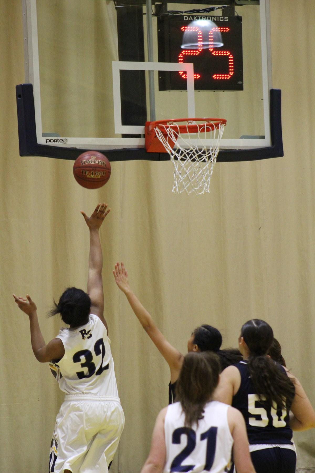 Basketball player shooting the ball while being guarded